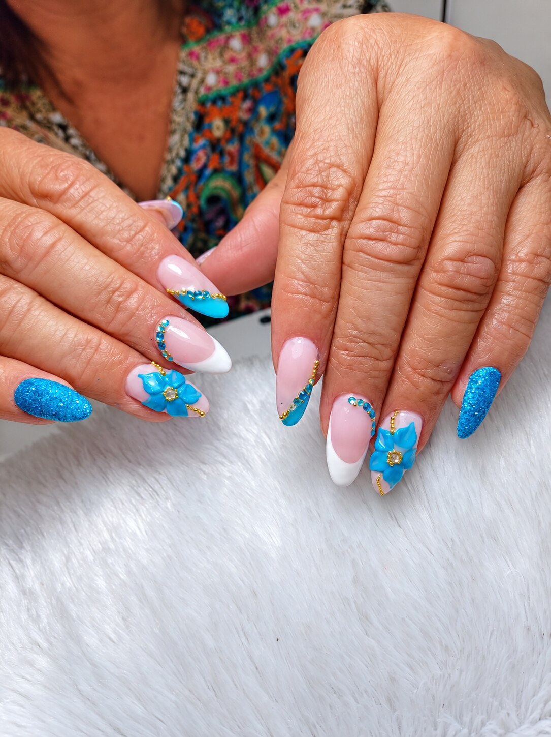Uñas azul turquesa con pedrería, flores y francesa blanca